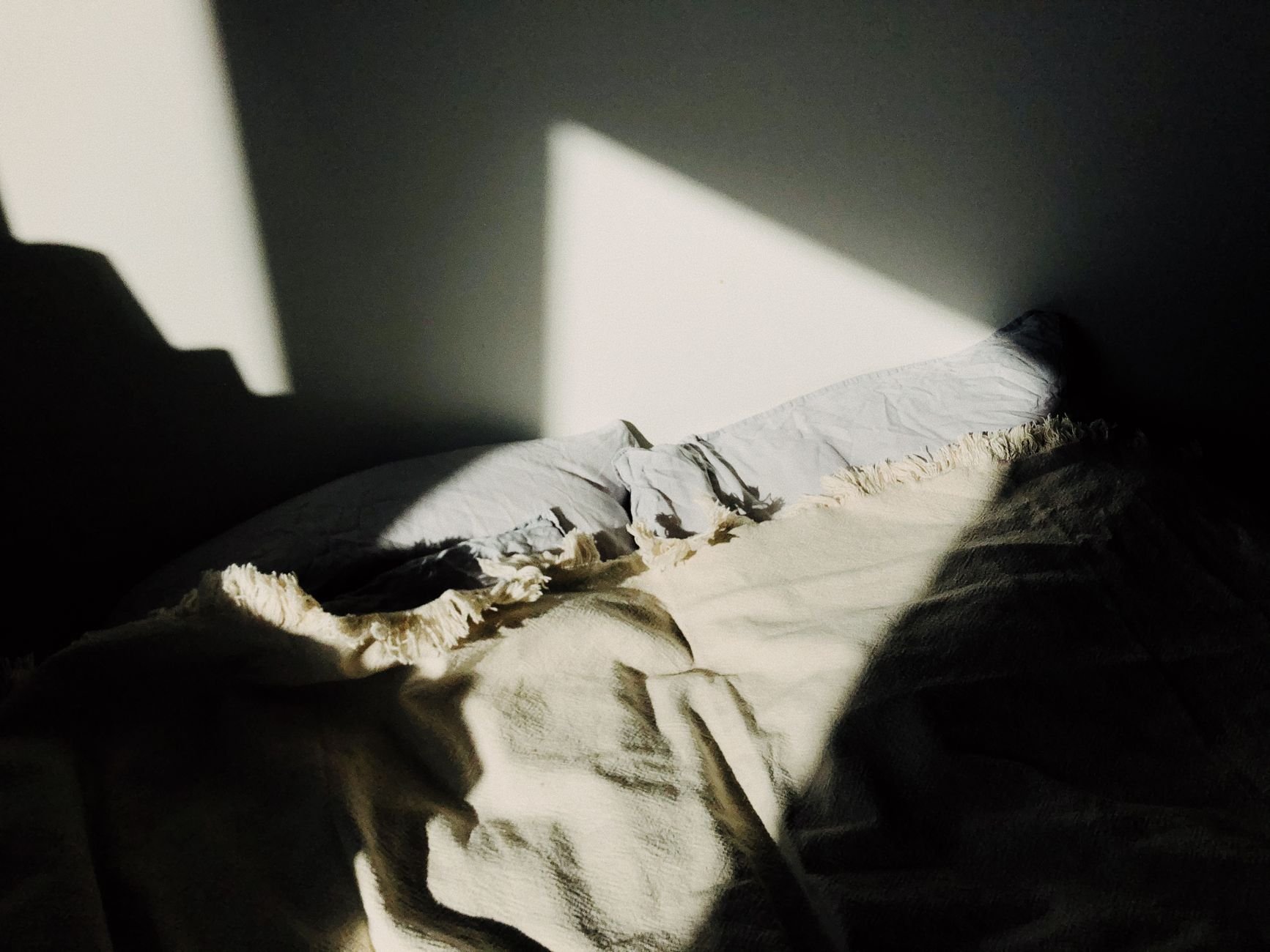 Warm sunlit bedroom with soft linen textures, embodying the Neve Home aesthetic